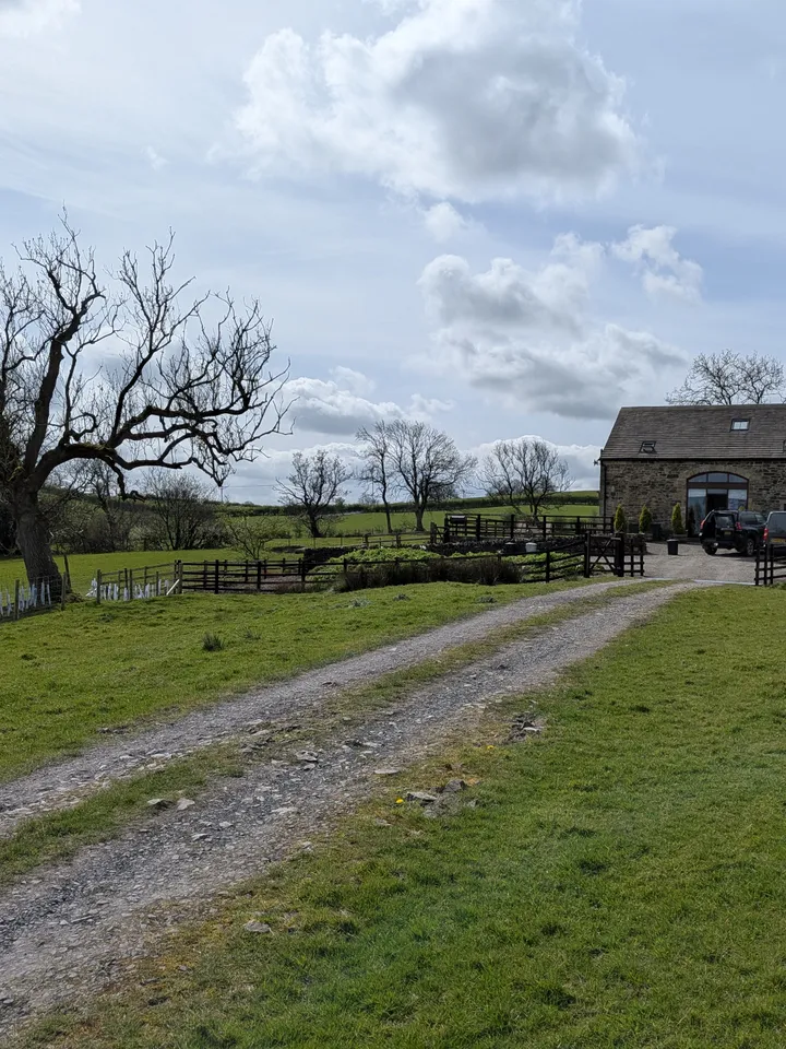 The lane approaching Hill Brook Barn — stone walls and open fields beyond