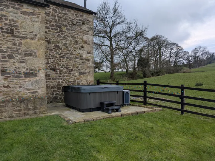 Private hot tub against original stone wall at Hill Brook Barn